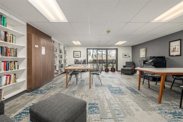 game room featuring built in features and a drop ceiling