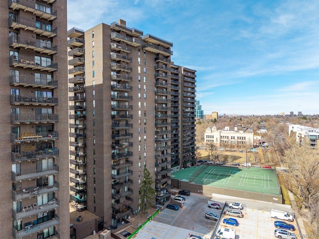 view of building exterior with a city view and uncovered parking