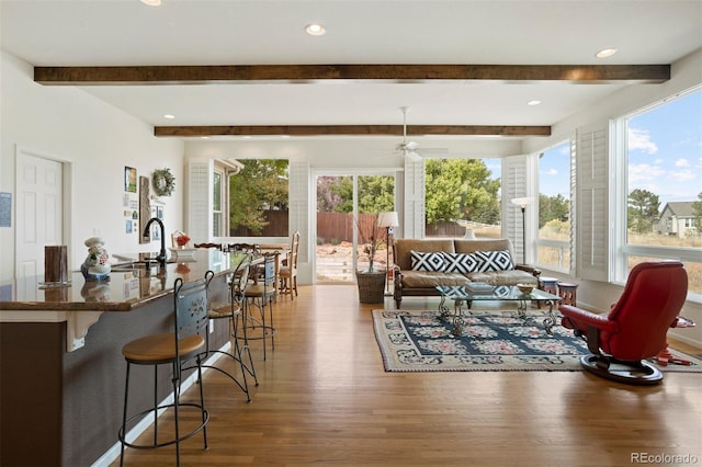 sunroom / solarium with beam ceiling, ceiling fan, sink, and a healthy amount of sunlight