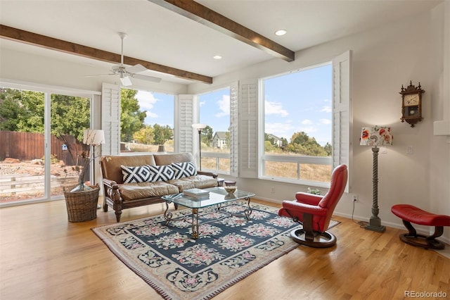 sunroom featuring beam ceiling and ceiling fan