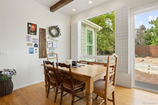 dining room featuring beamed ceiling and light wood-type flooring