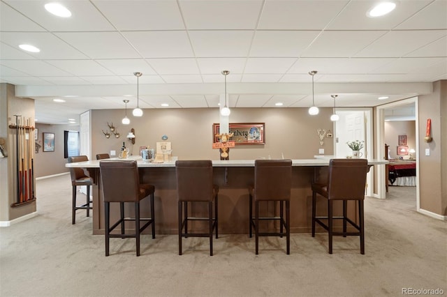 bar with light colored carpet and pendant lighting