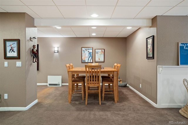 carpeted dining room with a drop ceiling