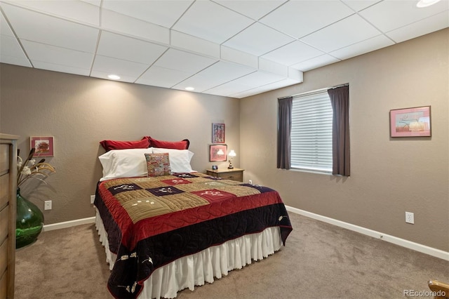 bedroom with carpet flooring and a drop ceiling