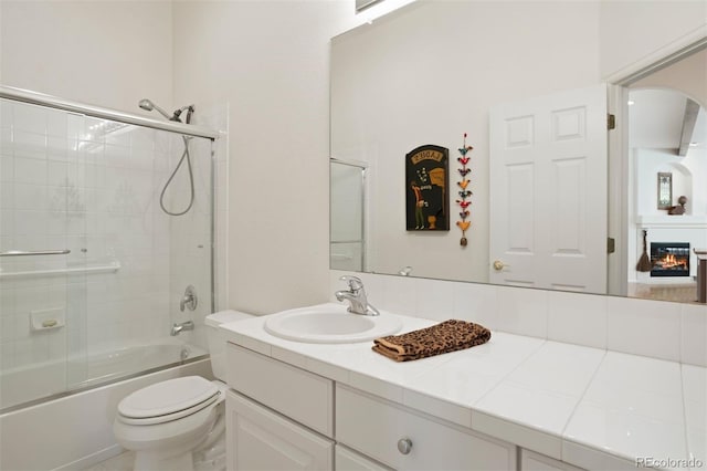 full bathroom featuring vanity, toilet, and bath / shower combo with glass door