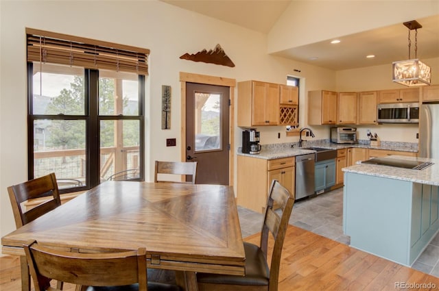 30490 Harvard Cir, Buena Vista, CO 81211 - kitchen featuring stainless steel appliances, light brown cabinetry, a sink, a chandelier, and vaulted ceiling
