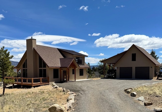 30490 Harvard Cir, Buena Vista, CO 81211 - view of front facade featuring gravel driveway, a wooden deck, a chimney, stucco siding, and a shingled roof