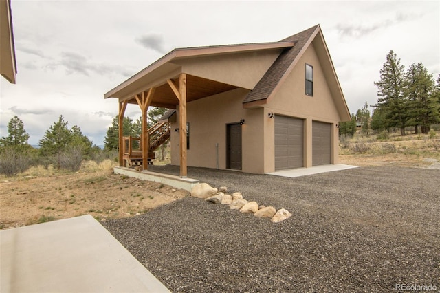 30490 Harvard Cir, Buena Vista, CO 81211 - view of front facade with roof with shingles, stairs, stucco siding, and a garage