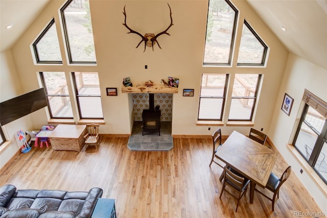30490 Harvard Cir, Buena Vista, CO 81211 - living room featuring wood finished floors, high vaulted ceiling, a wood stove, and baseboards