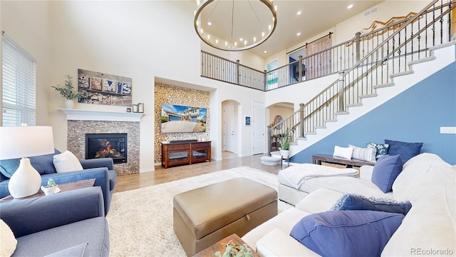 5932 Eldora St, Golden, CO 80403 - living room featuring arched walkways, a high ceiling, wood finished floors, stairway, and a chandelier