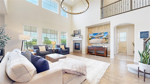 5932 Eldora St, Golden, CO 80403 - living room with a high ceiling, a glass covered fireplace, arched walkways, plenty of natural light, and wood finished floors