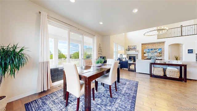 5932 Eldora St, Golden, CO 80403 - dining room with light wood-style floors, a chandelier, recessed lighting, arched walkways, and baseboards