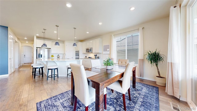 5932 Eldora St, Golden, CO 80403 - dining area featuring arched walkways, light wood-type flooring, recessed lighting, and baseboards