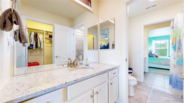 5932 Eldora St, Golden, CO 80403 - bathroom featuring vanity, toilet, tile patterned floors, a spacious closet, and connected bathroom