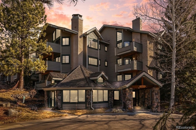 exterior space with stone siding and a chimney