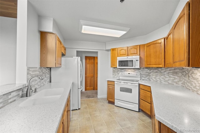 kitchen featuring a sink, white appliances, backsplash, and brown cabinetry