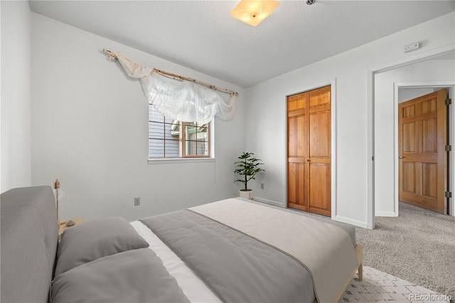 carpeted bedroom featuring baseboards and a textured ceiling