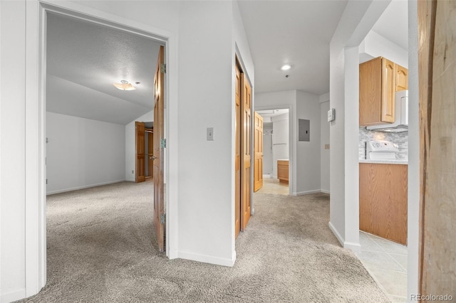 corridor featuring electric panel, baseboards, light carpet, and vaulted ceiling