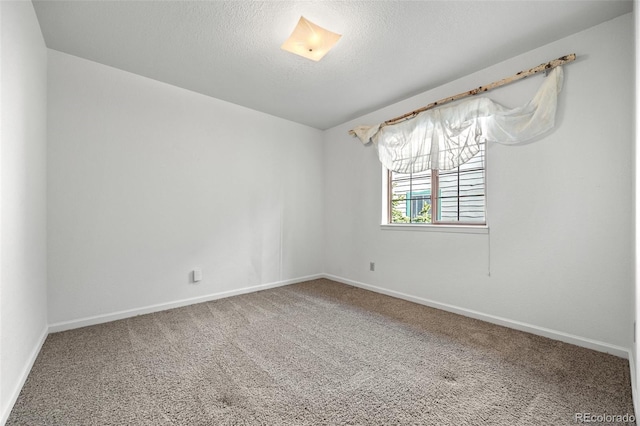 carpeted empty room featuring baseboards and a textured ceiling