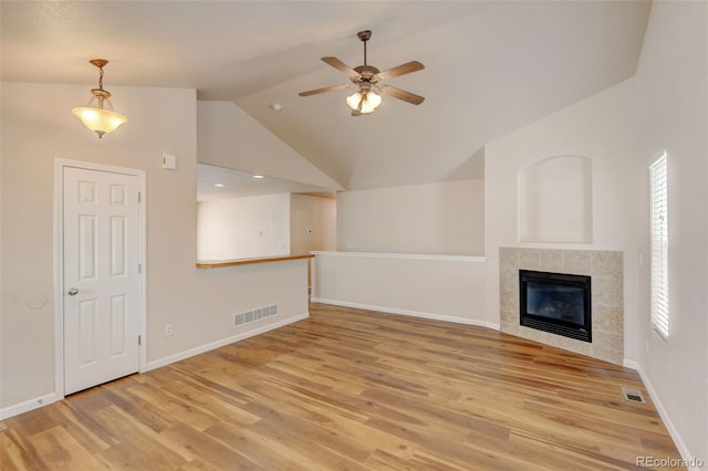 6836 Loudon St, Wellington, CO 80549 - unfurnished living room with light wood finished floors, a ceiling fan, a tiled fireplace, and high vaulted ceiling