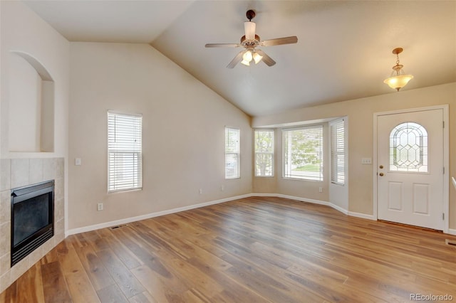 6836 Loudon St, Wellington, CO 80549 - unfurnished living room featuring light wood finished floors, a tile fireplace, ceiling fan, and vaulted ceiling