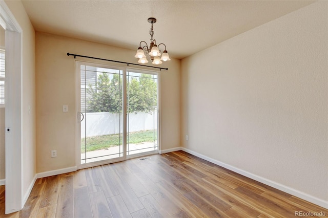6836 Loudon St, Wellington, CO 80549 - unfurnished room featuring a chandelier and light wood-style floors