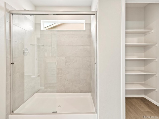 bathroom with hardwood / wood-style floors and walk in shower