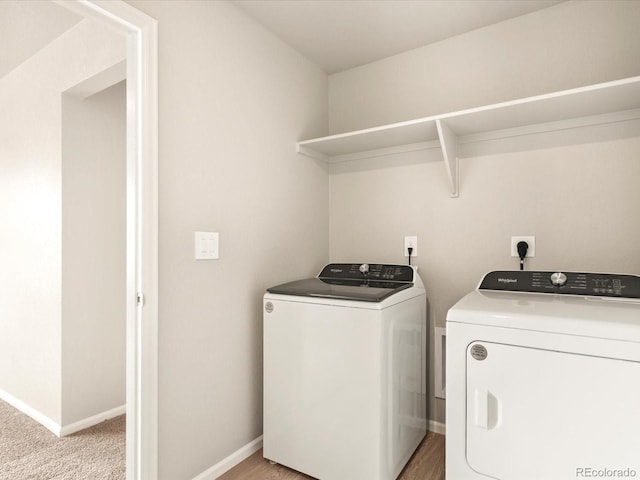 laundry room with washer and dryer and light carpet