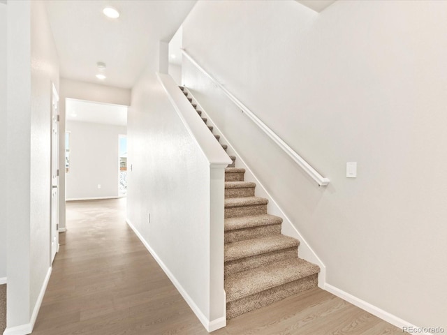 stairs with recessed lighting, baseboards, and wood finished floors