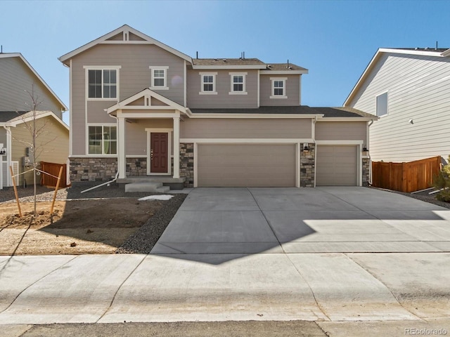 view of front facade with driveway, stone siding, a garage, and fence