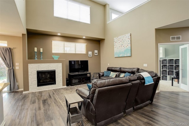 15122 Fillmore Way, Thornton, CO 80602 - living area featuring a towering ceiling, dark wood finished floors, and a fireplace