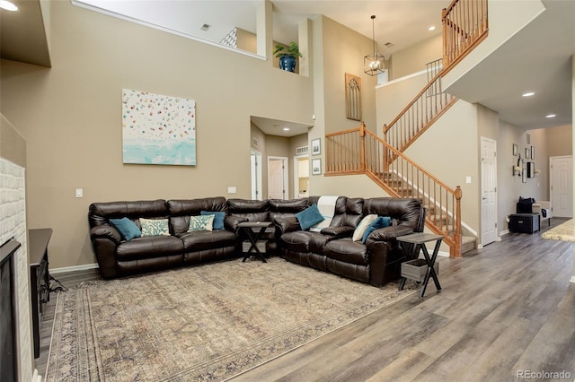 15122 Fillmore Way, Thornton, CO 80602 - living area featuring stairs, wood finished floors, recessed lighting, a fireplace, and a high ceiling