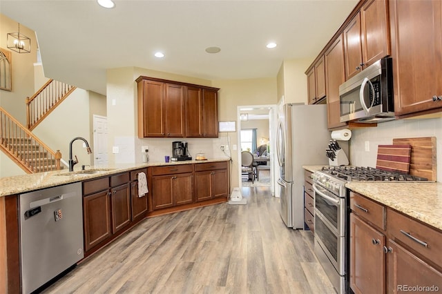 15122 Fillmore Way, Thornton, CO 80602 - kitchen featuring appliances with stainless steel finishes, light wood-style flooring, backsplash, a peninsula, and recessed lighting