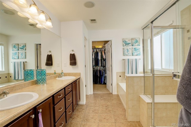 15122 Fillmore Way, Thornton, CO 80602 - bathroom featuring plenty of natural light, a bath, double vanity, and tile patterned floors