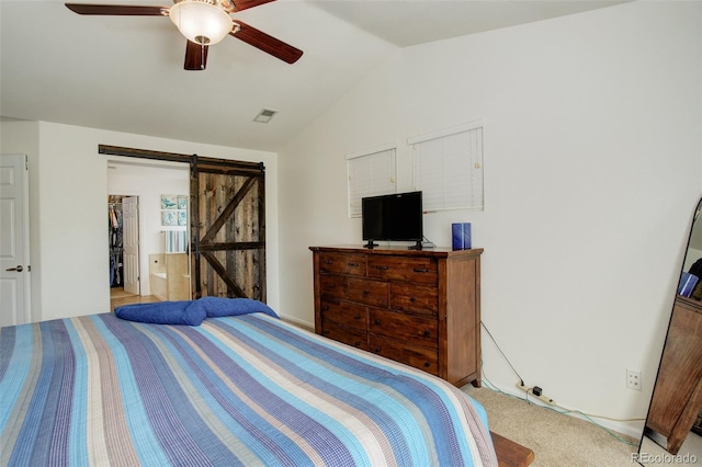 15122 Fillmore Way, Thornton, CO 80602 - bedroom featuring lofted ceiling, a barn door, a ceiling fan, light carpet, and a spacious closet