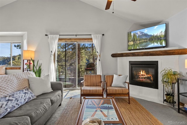 living area with lofted ceiling, a tiled fireplace, a ceiling fan, and carpet