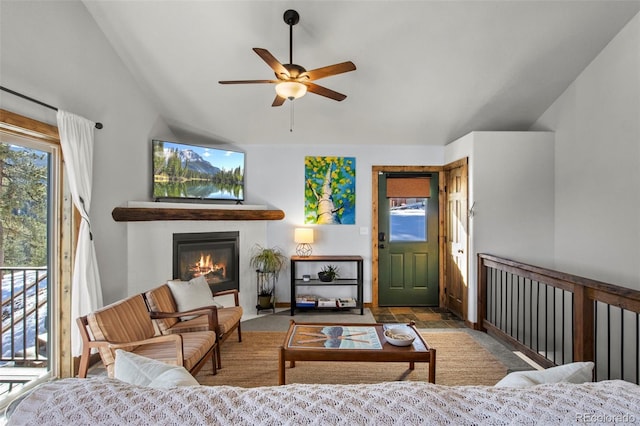 living room featuring lofted ceiling, ceiling fan, and a glass covered fireplace