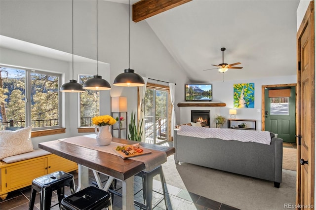 interior space with a wealth of natural light, high vaulted ceiling, beamed ceiling, and a glass covered fireplace