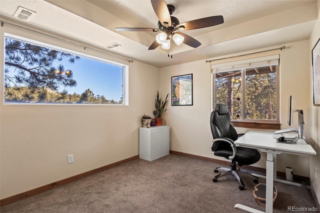 carpeted home office with visible vents, ceiling fan, and baseboards