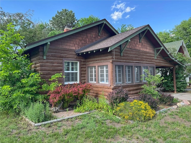 620 Walnut St, Windsor, CO 80550 - view of property exterior featuring a chimney, log siding, roof with shingles, and entry steps