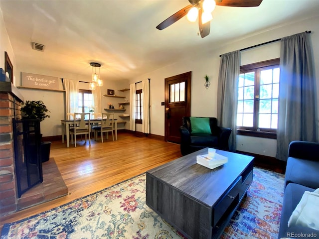 620 Walnut St, Windsor, CO 80550 - living room with wood finished floors, ceiling fan, and a brick fireplace