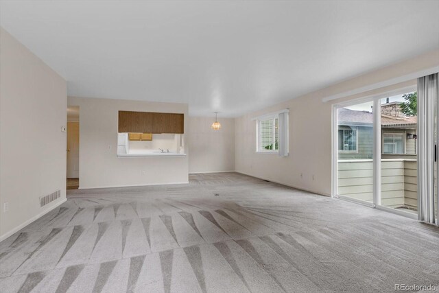 8406 Everett Way Unit C, Arvada, CO 80005 - unfurnished living room featuring light carpet and baseboards