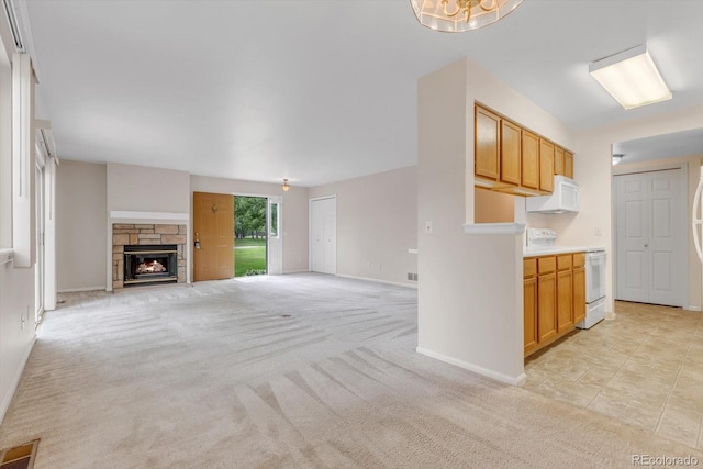 8406 Everett Way Unit C, Arvada, CO 80005 - unfurnished living room featuring light carpet and a stone fireplace