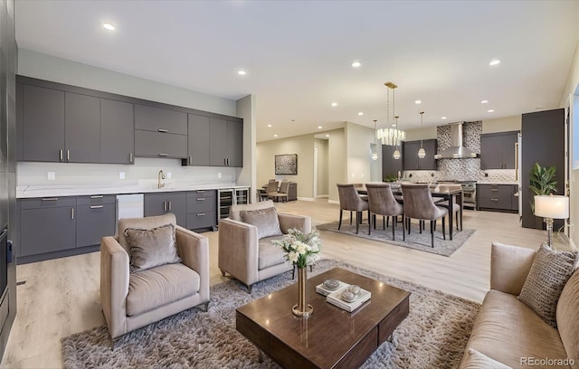 living room featuring wine cooler, sink, and light wood-type flooring