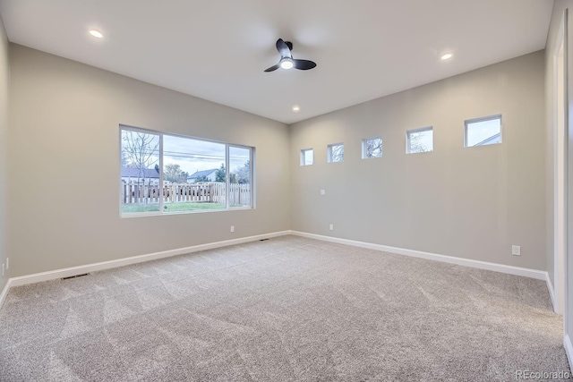 empty room with plenty of natural light, ceiling fan, and light colored carpet