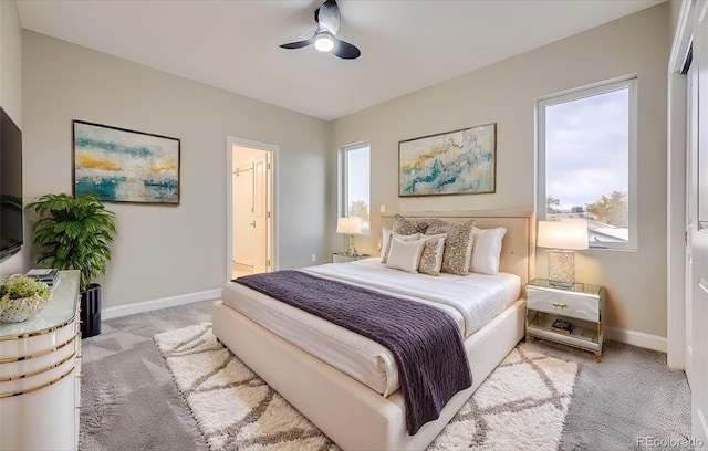 bedroom featuring ensuite bath, light carpet, and ceiling fan