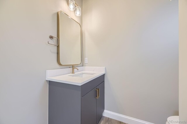 bathroom featuring vanity, hardwood / wood-style flooring, and toilet