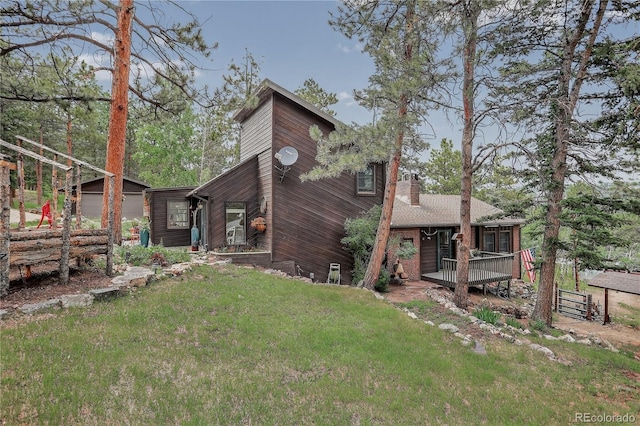 119 Yew Ln, Bailey, CO 80421 - back of house featuring a chimney, an outdoor structure, a yard, and a deck