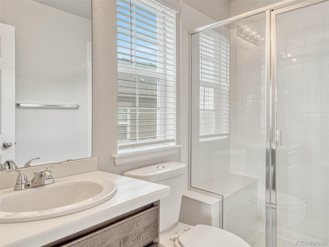 bathroom with toilet, a shower with door, and vanity