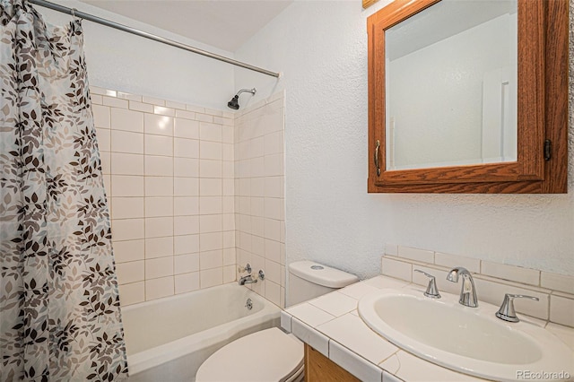 full bath with vanity, toilet, a textured wall, and shower / tub combo